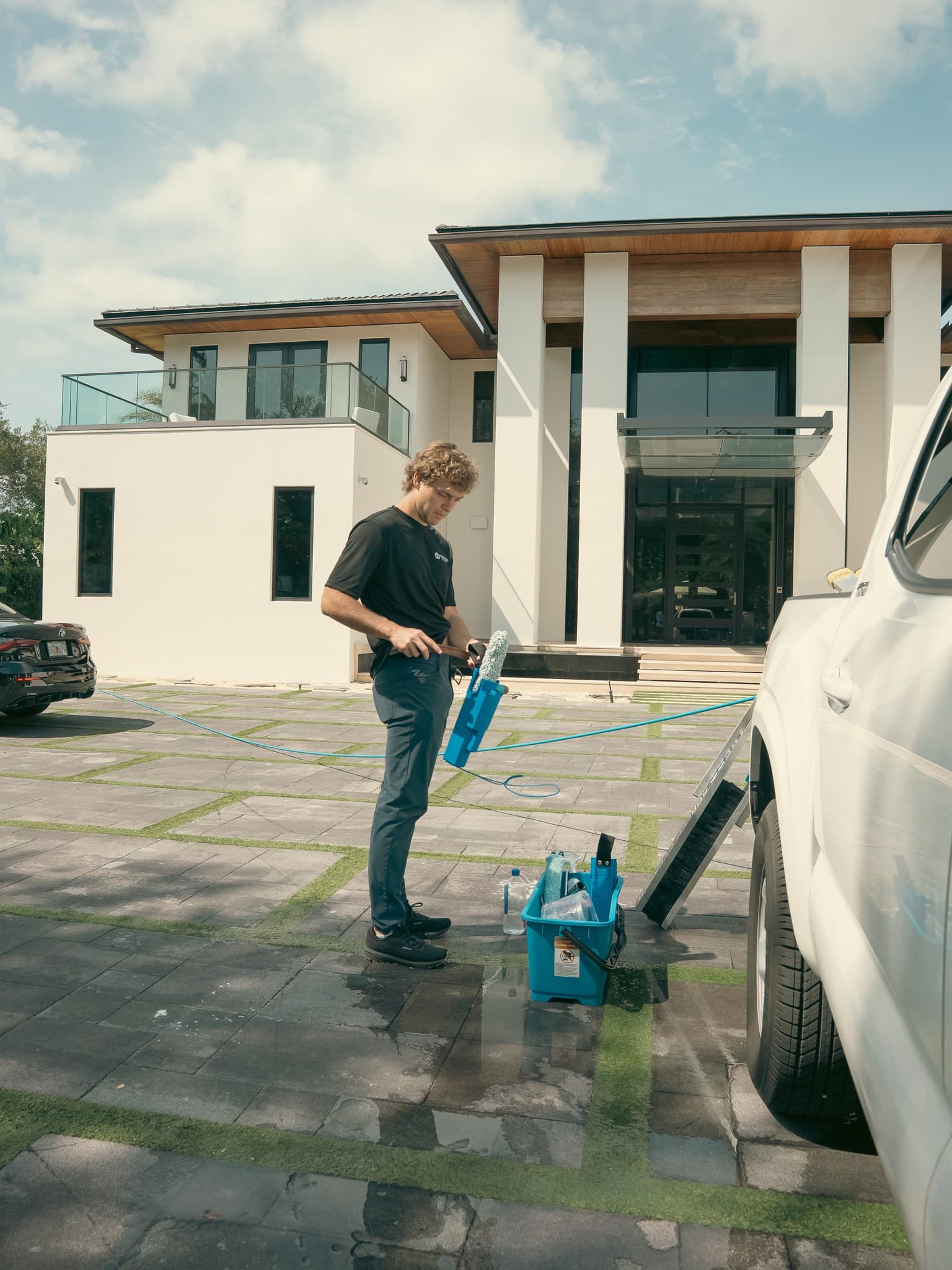 A Fresh Frames technician cleaning windows at a modern Florida home