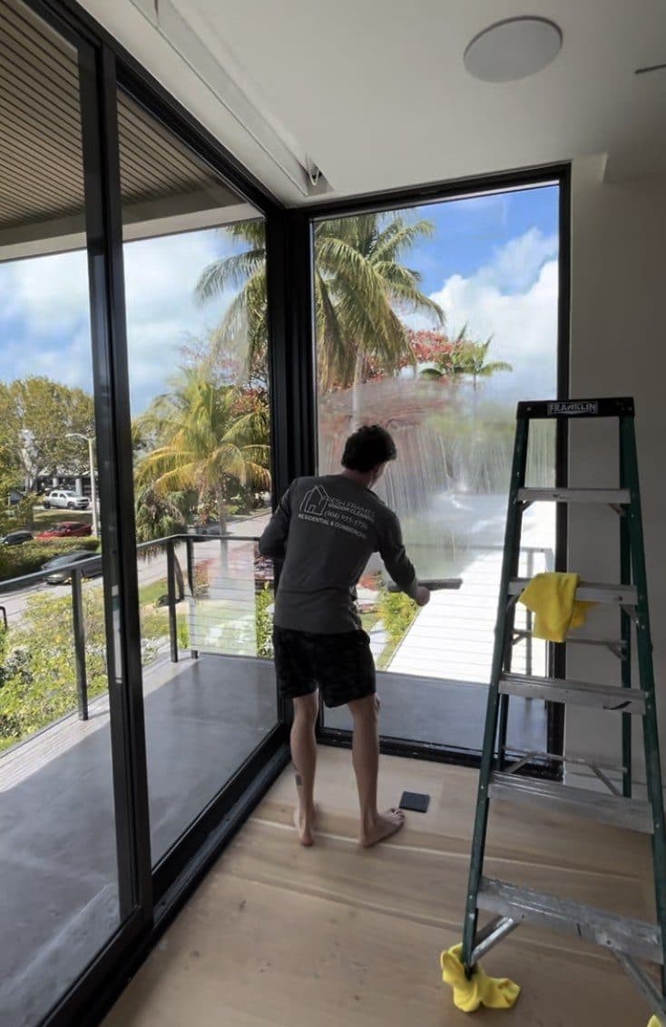 Cleaning second-story windows from a ladder on a Florida home