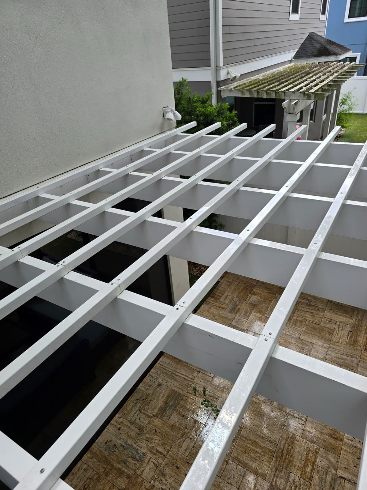 After — the same pergola washed back to bright, clean white, the algae gone from every beam