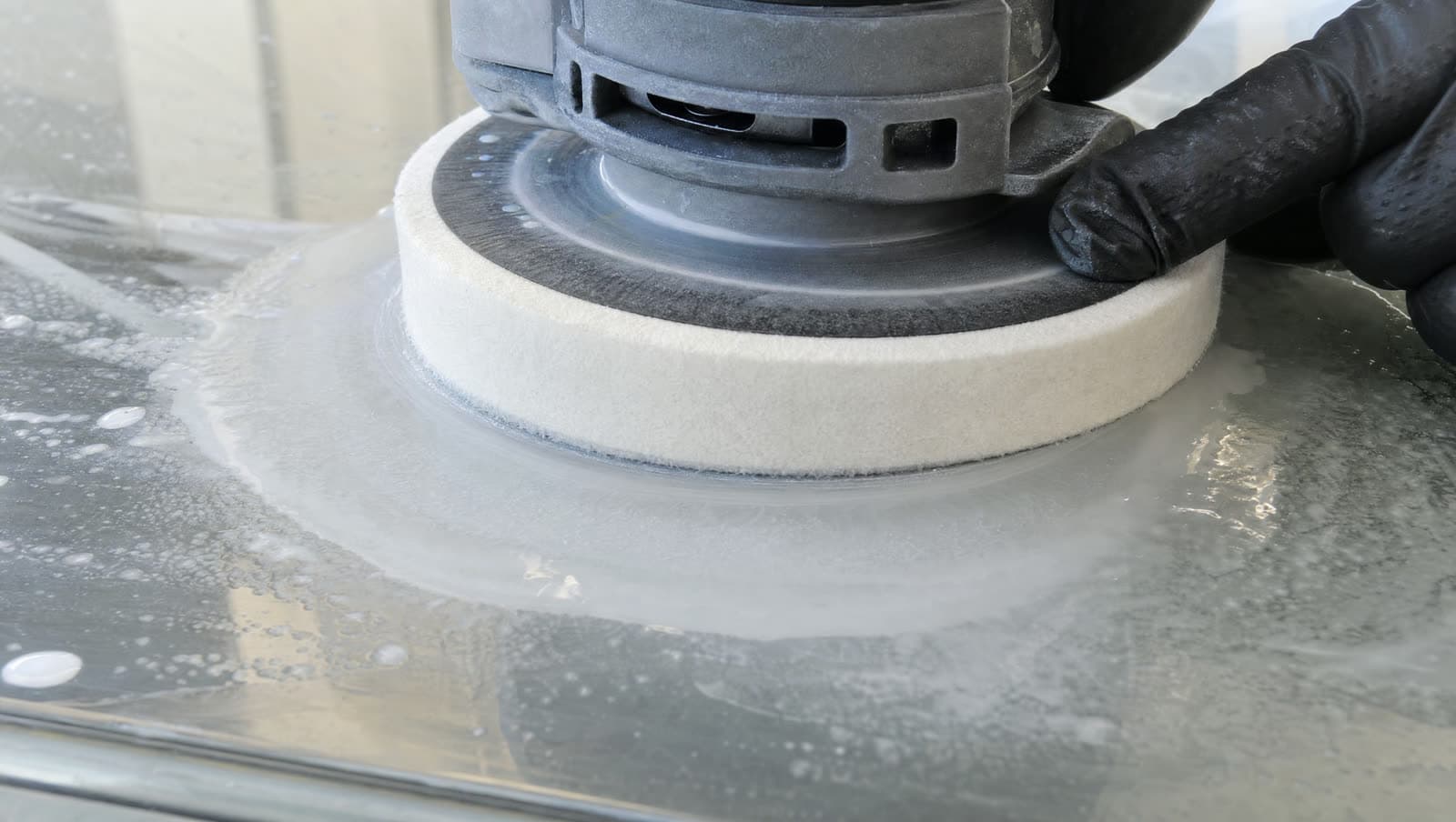 Felt polishing pad with cerium oxide compound working on a glass surface